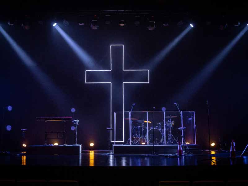 Fácil configuración del escenario de la iglesia con una cruz iluminada por LED como telón de fondo